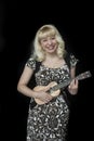 Beautiful Young Woman with Blond Hair Playing Ukulele Royalty Free Stock Photo