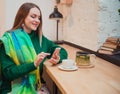 A beautiful young woman with blond hair is sitting in a cafe. Shop. Online shopping. She drinks delicious tea.