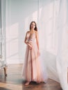 young woman Blonde haire legant beige ball gown. evening long pink trendy dress