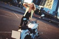 Beautiful young woman blonde standing near a motorcycle on the b Royalty Free Stock Photo