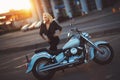 Beautiful young woman blonde standing near a motorcycle on the b Royalty Free Stock Photo