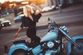 Beautiful young woman blonde standing near a motorcycle on the b Royalty Free Stock Photo