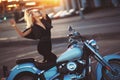 Beautiful young woman blonde standing near a motorcycle on the b Royalty Free Stock Photo