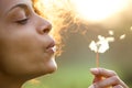 Beautiful young woman blowing dandelion flower Royalty Free Stock Photo