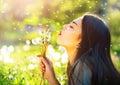 Beautiful young woman blowing dandelions