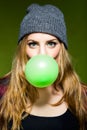 Beautiful young woman blowing green bubblegum. .