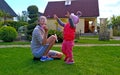 Beautiful young woman blows soap bubbles for her little daughter. Happy girl runs after the soap bubbles that her mom Royalty Free Stock Photo