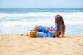 Beautiful young girl using phone on the beach on vacation