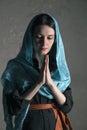 Beautiful young woman in a blue shawl praying Royalty Free Stock Photo