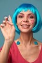 Beautiful young woman with blue wig and bright make-up in soap bubbles. Fashion model girl with creative color makeup Royalty Free Stock Photo