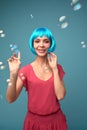 Beautiful young woman with blue wig and bright make-up in soap bubbles. Fashion model girl with creative color makeup Royalty Free Stock Photo