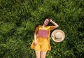 Beautiful young woman with book lying on green meadow, top view. Summer reading Royalty Free Stock Photo