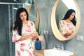 Beautiful young woman with bottle of perfume at bathroom. Girl holding bottle of perfume. Fragrance smell