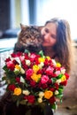 Beautiful young woman with a bouquet of roses and blurred cat Royalty Free Stock Photo