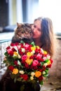 Beautiful young woman with a bouquet of roses and blurred cat Royalty Free Stock Photo