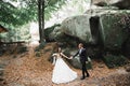 Beautiful young woman bride holds the hand of a man on the background of the mountains. Follow me Royalty Free Stock Photo