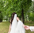 Beautiful young woman bride holds the hand of a man in outdoors. Follow me Royalty Free Stock Photo