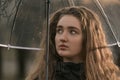 Beautiful young woman with brown hair dreaming stare. Portrait of natural beauty girl. Woman under umbrella Royalty Free Stock Photo