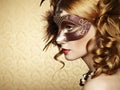 Beautiful young woman in brown venetian mask