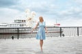 Beautiful young woman with bunch of balloons near sightseeing boat