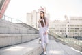 Beautiful young woman in a business purple suit against a city background