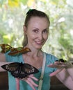Beautiful young woman in a butterfly park with large tropical butterflies in her arms Royalty Free Stock Photo