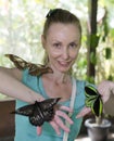 Beautiful young woman in a butterfly park with large tropical butterflies in her arms Royalty Free Stock Photo