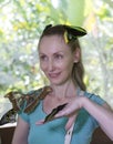 Beautiful young woman in a butterfly park with large tropical butterflies in her arms Royalty Free Stock Photo