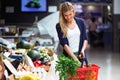 Beautiful young woman buying fresh vegetables in the market. Royalty Free Stock Photo