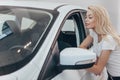 Beautiful young woman buying new car at the dealership Royalty Free Stock Photo