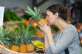 beautiful young woman buying pineapple in fruit market Royalty Free Stock Photo