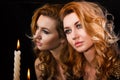 Beautiful young woman with candles near the mirror Royalty Free Stock Photo