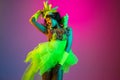 Beautiful young woman in carnival and masquerade costume on gradient studio background in neon light Royalty Free Stock Photo