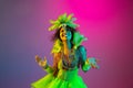 Beautiful young woman in carnival and masquerade costume on gradient studio background in neon light Royalty Free Stock Photo