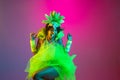 Beautiful young woman in carnival and masquerade costume on gradient studio background in neon light Royalty Free Stock Photo