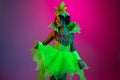 Beautiful young woman in carnival and masquerade costume on gradient studio background in neon light Royalty Free Stock Photo