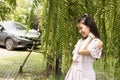 Beautiful young woman in casual clothes walks through green forest in summer and admires wild flowers, concept Leisure of young Royalty Free Stock Photo