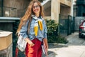 A beautiful young woman in a casual outfit and eyeglasses with a backpack and books posing outdoors. Pretty female student with Royalty Free Stock Photo