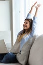 Beautiful young woman celebrating a succes while working with laptop at home. Royalty Free Stock Photo