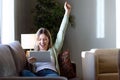 Beautiful young woman celebrating a success while using her digital tablet at home. Royalty Free Stock Photo