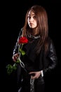 Beautiful young woman with chains and a red rose