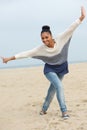 Beautiful young woman with cheerful expression walking on beach Royalty Free Stock Photo