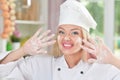 Beautiful young woman in chefs hat preparing delicious cookies