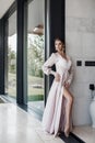 Beautiful young woman in a chic pink bathrobe spends time alone in an expensive hotel in the summer during the holidays Royalty Free Stock Photo