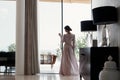 Beautiful young woman in a chic pink bathrobe spends time alone in an expensive hotel in the summer during the holidays Royalty Free Stock Photo
