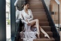 Beautiful young woman in a chic pink bathrobe spends time alone in an expensive hotel in the summer during the holidays Royalty Free Stock Photo