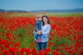 Beautiful young woman with child girl in poppy field. happy family having fun in nature. outdoor portrait in poppies. mother with Royalty Free Stock Photo