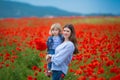 Beautiful young woman with child girl in poppy field. happy family having fun in nature. outdoor portrait in poppies. mother with Royalty Free Stock Photo