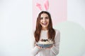 Beautiful young woman with chocolate Easter eggs and bunny ears on color background Royalty Free Stock Photo