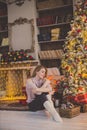 Beautiful young woman in a Christmas interior. Dressing a Christmas tree.